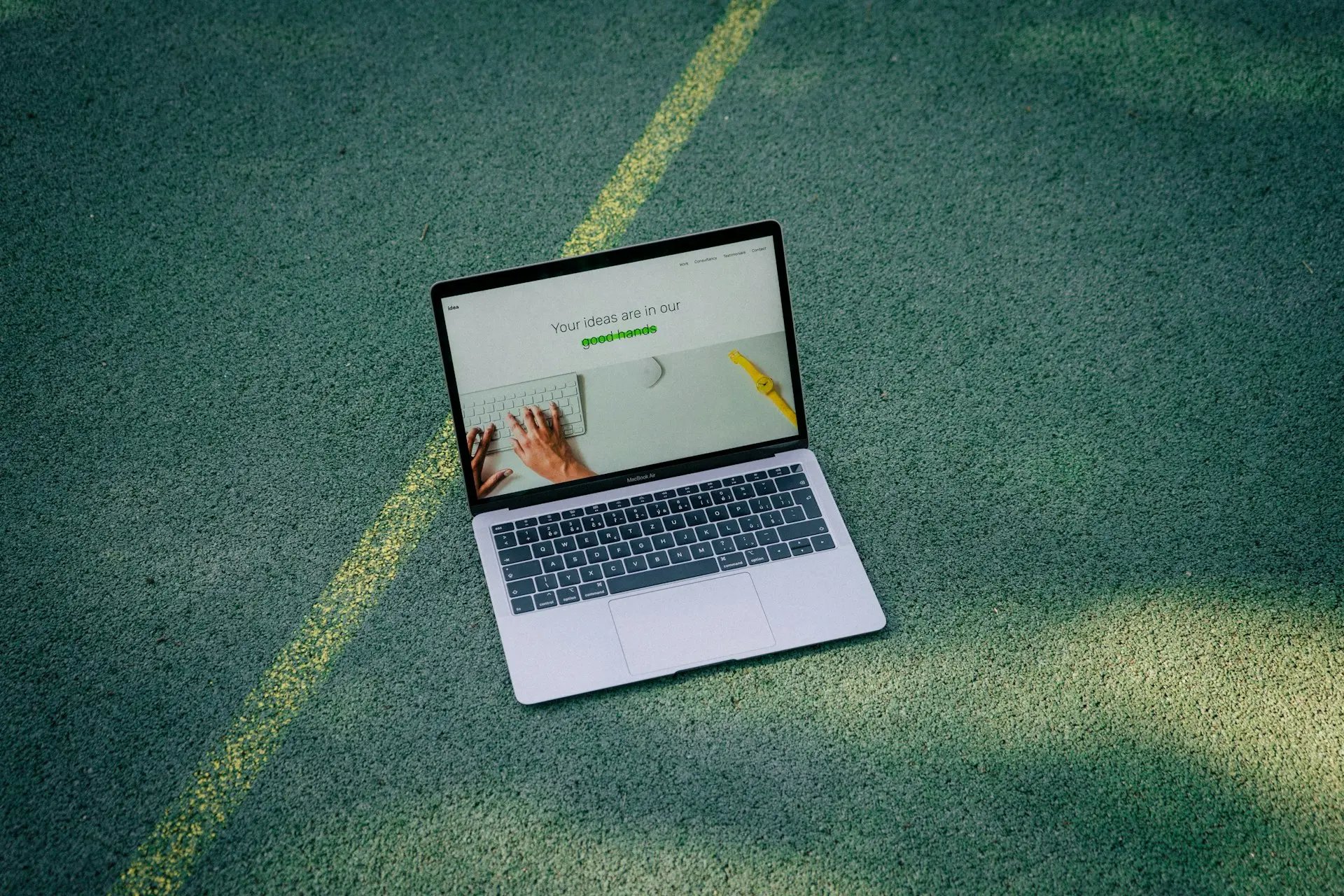 a laptop computer sitting on top of a tennis court
